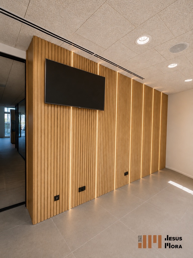 Pared de lamas de madera con iluminación vertical y pantalla integrada